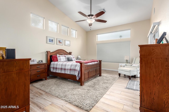 bedroom with ceiling fan, lofted ceiling, and light wood-type flooring