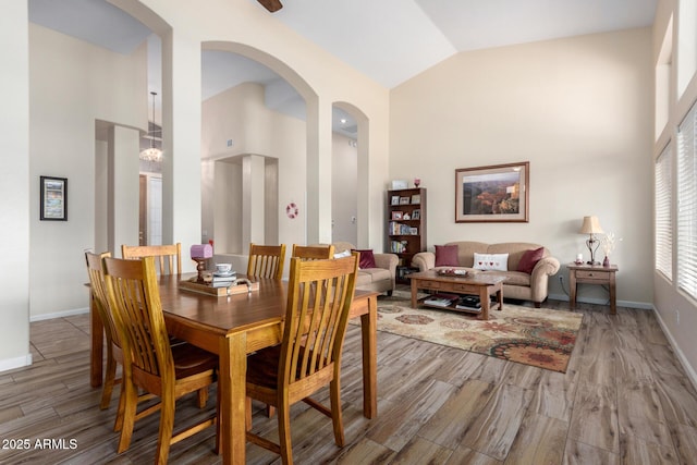 dining room with hardwood / wood-style floors and high vaulted ceiling