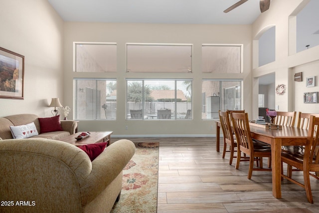 interior space with light hardwood / wood-style floors, ceiling fan, and a high ceiling