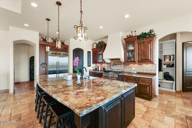 28025 N 156th Pl, Scottsdale, AZ 85262 - kitchen with high end appliances, custom exhaust hood, arched walkways, stone tile flooring, and a sink