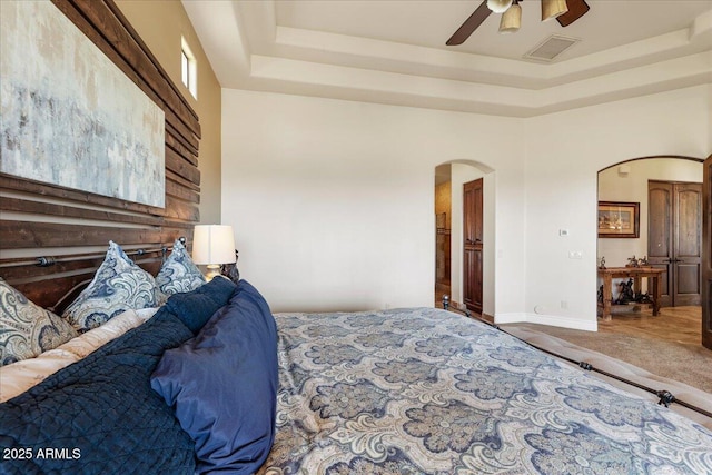 28025 N 156th Pl, Scottsdale, AZ 85262 - carpeted bedroom with arched walkways, a tray ceiling, a ceiling fan, and baseboards