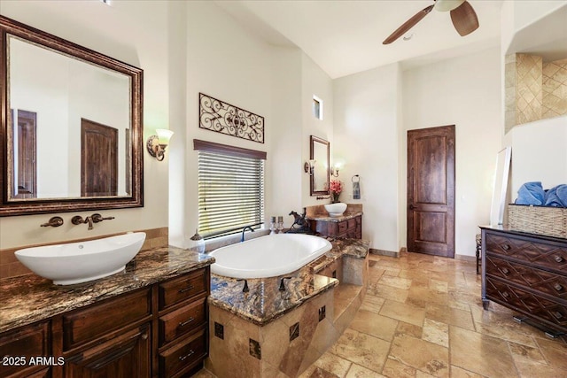 28025 N 156th Pl, Scottsdale, AZ 85262 - bathroom featuring a high ceiling, stone tile flooring, ceiling fan, a garden tub, and two vanities
