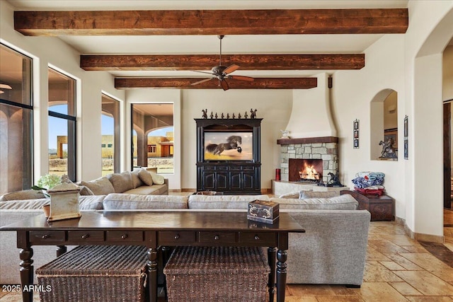 28025 N 156th Pl, Scottsdale, AZ 85262 - living area featuring stone tile floors, ceiling fan, a stone fireplace, baseboards, and beam ceiling