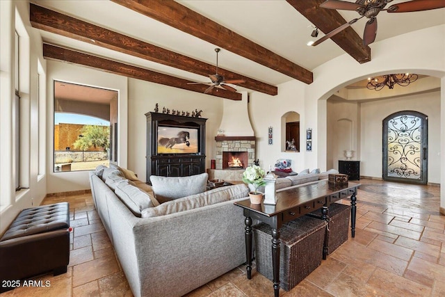 28025 N 156th Pl, Scottsdale, AZ 85262 - living area with ceiling fan, stone tile flooring, arched walkways, beamed ceiling, and a stone fireplace