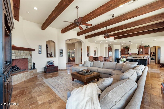 28025 N 156th Pl, Scottsdale, AZ 85262 - living area featuring a ceiling fan, arched walkways, stone tile flooring, beamed ceiling, and recessed lighting