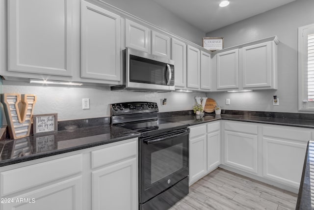 kitchen with black range with electric cooktop, light wood-type flooring, and white cabinetry