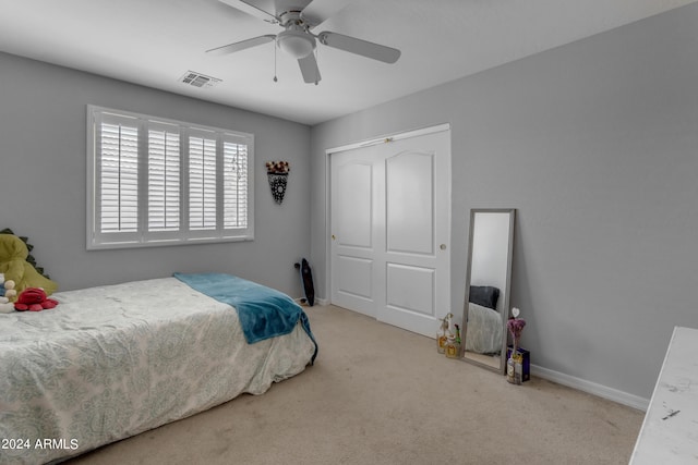 carpeted bedroom featuring ceiling fan and a closet