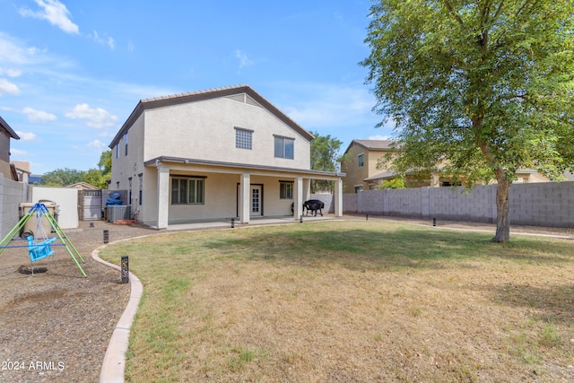 rear view of property featuring a yard, a patio area, and central air condition unit