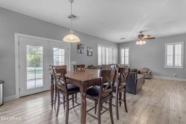 dining space with ceiling fan and light wood-type flooring