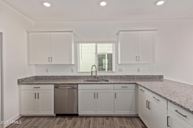 kitchen featuring recessed lighting, a sink, white cabinets, stainless steel dishwasher, and wood tiled floor