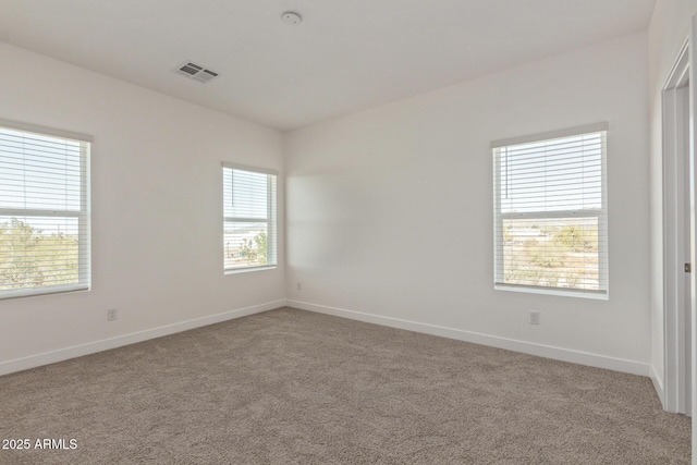 carpeted empty room featuring visible vents and baseboards