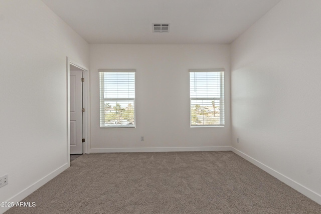 carpeted empty room featuring visible vents and baseboards