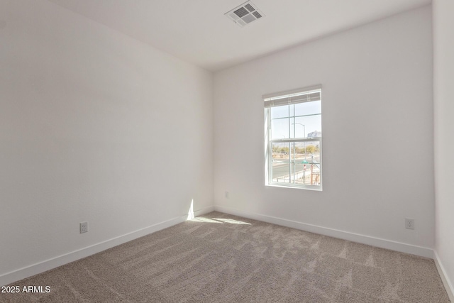 carpeted spare room with visible vents and baseboards