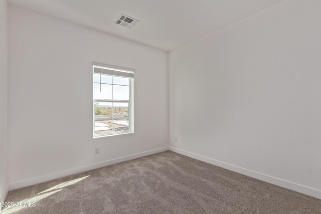 carpeted spare room with visible vents and baseboards