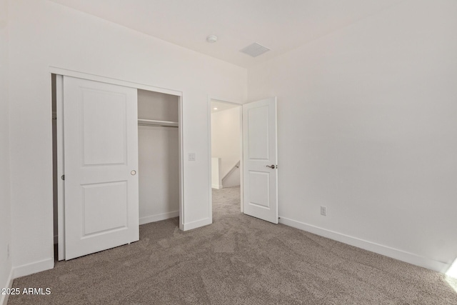 unfurnished bedroom featuring a closet, carpet flooring, and baseboards