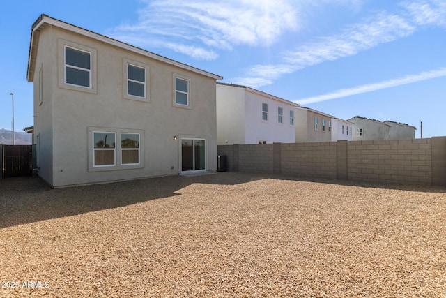 back of property featuring a fenced backyard and stucco siding