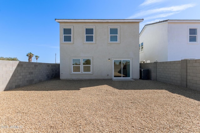 rear view of property with a fenced backyard, cooling unit, and stucco siding