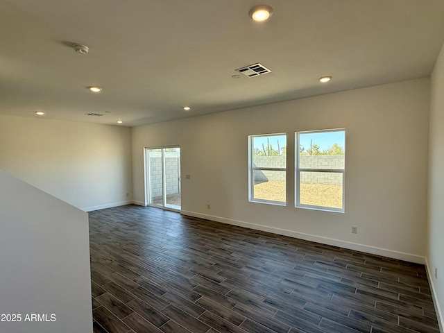 empty room with baseboards, dark wood finished floors, visible vents, and recessed lighting