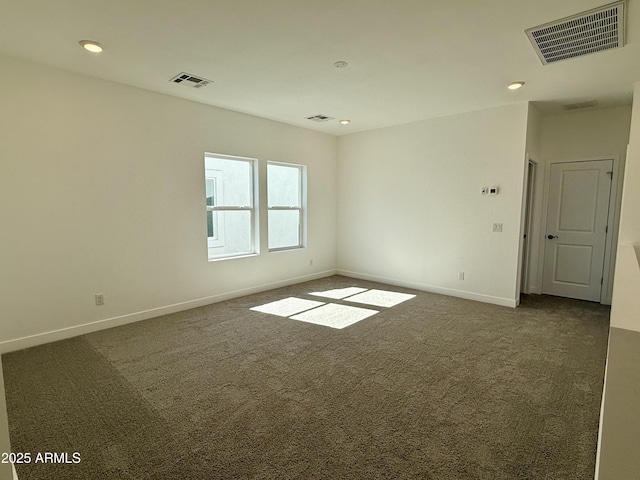 spare room with recessed lighting, dark carpet, visible vents, and baseboards