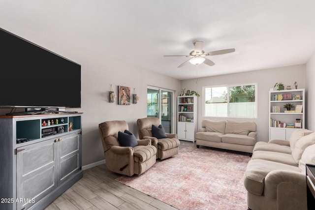 living area with ceiling fan, light wood finished floors, and baseboards