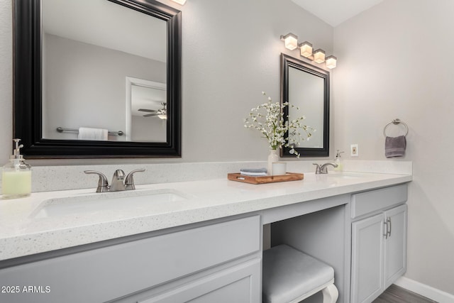 bathroom with double vanity, baseboards, a ceiling fan, and a sink