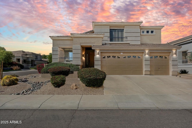 traditional home featuring stucco siding, concrete driveway, and a garage