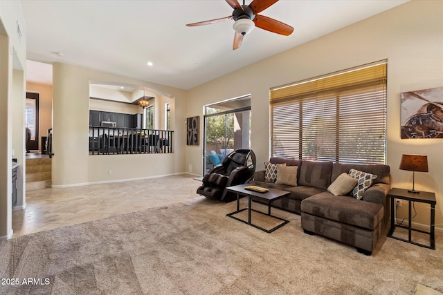 carpeted living room with ceiling fan, baseboards, recessed lighting, tile patterned flooring, and a chandelier