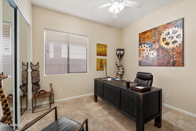 carpeted home office with a ceiling fan and baseboards