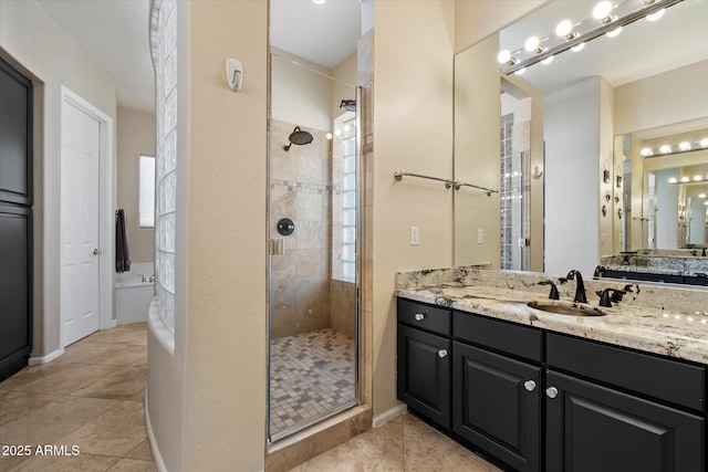 bathroom with a shower stall, vanity, tile patterned flooring, and a garden tub