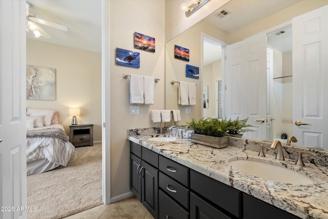 ensuite bathroom featuring ceiling fan, double vanity, baseboards, and tile patterned floors