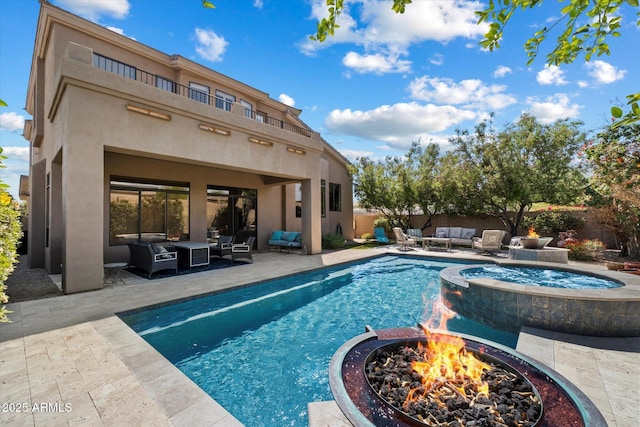 view of pool featuring an outdoor living space with a fire pit, a patio area, a pool with connected hot tub, and fence