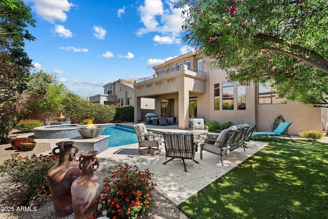 view of swimming pool featuring an outdoor living space, a patio, a pool with connected hot tub, and a yard