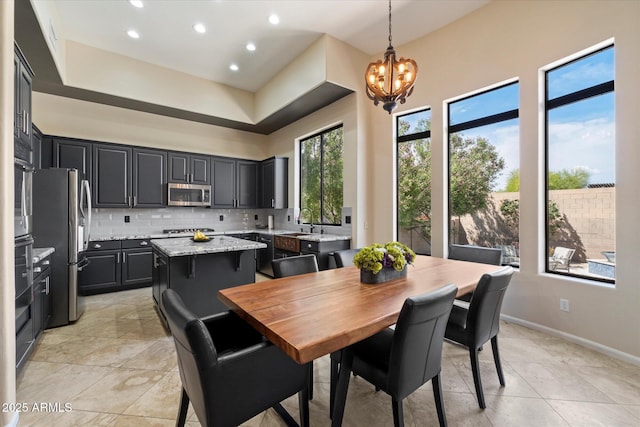 dining space featuring a chandelier, recessed lighting, a towering ceiling, baseboards, and light tile patterned floors