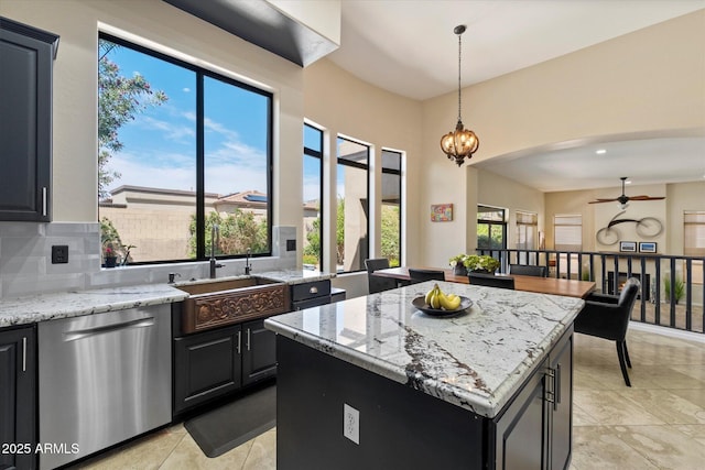 kitchen with dishwasher, a sink, a center island, a ceiling fan, and light tile patterned floors