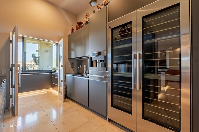 kitchen with sink, light tile patterned floors, and wine cooler