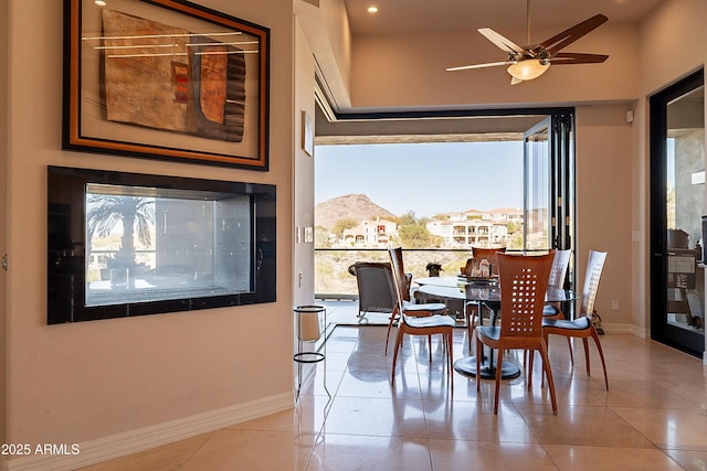 dining space featuring ceiling fan, a mountain view, and tile patterned flooring