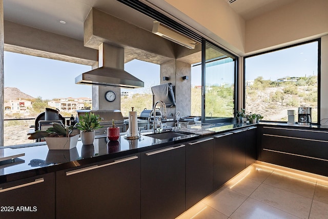 kitchen featuring light tile patterned floors, island range hood, sink, and a wealth of natural light