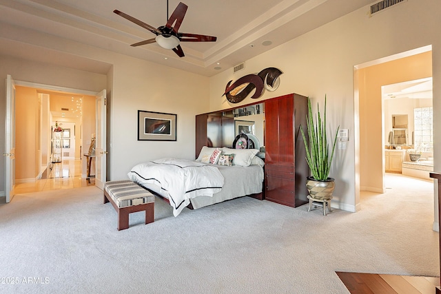 bedroom with a raised ceiling and light carpet