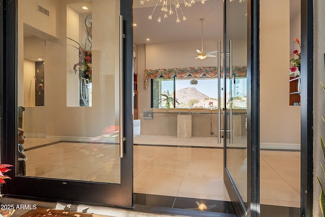 entryway with tile patterned flooring, a mountain view, and ceiling fan