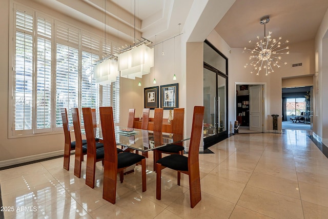 dining area featuring light tile patterned flooring, a towering ceiling, and a notable chandelier