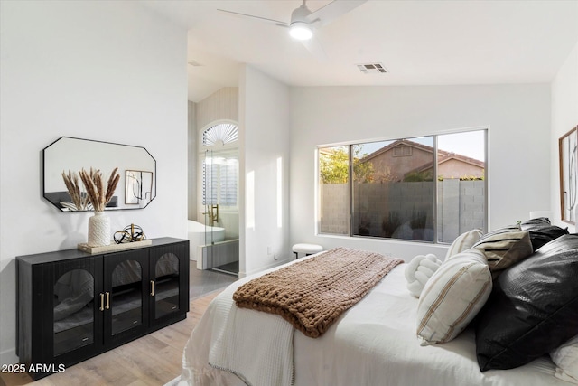 bedroom with lofted ceiling, multiple windows, light hardwood / wood-style floors, and ceiling fan