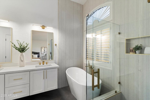 bathroom featuring a healthy amount of sunlight, plus walk in shower, vanity, and tile walls