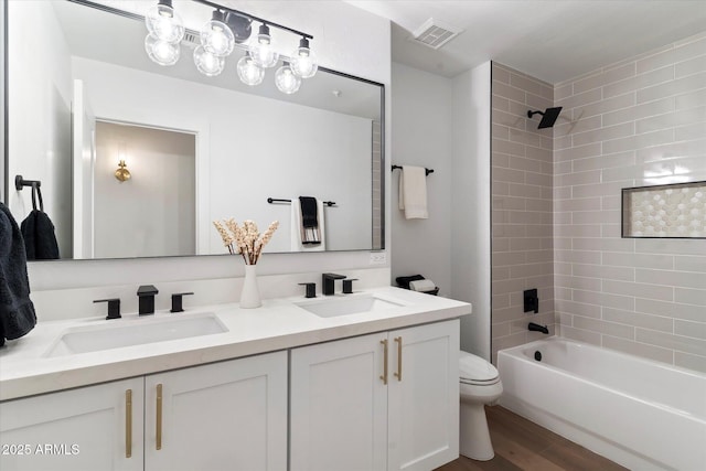 full bathroom with vanity, toilet, tiled shower / bath combo, and wood-type flooring