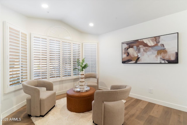 sitting room with wood-type flooring and vaulted ceiling