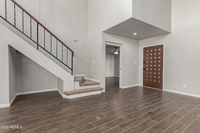 foyer with ceiling fan and a towering ceiling