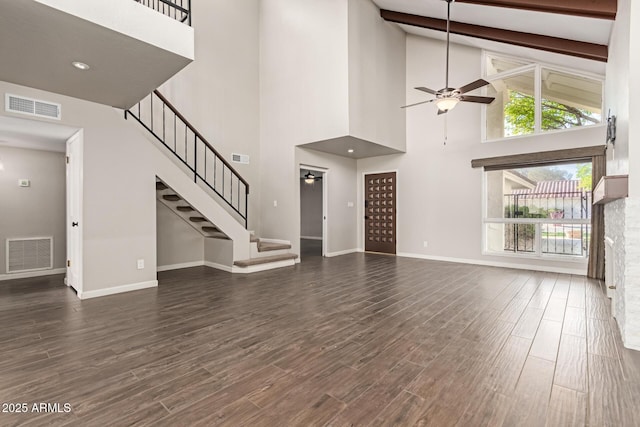 unfurnished living room with beamed ceiling, high vaulted ceiling, and ceiling fan