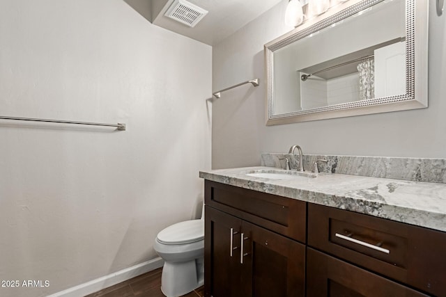 bathroom with hardwood / wood-style floors, vanity, and toilet