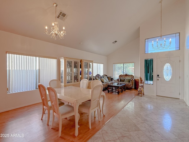 dining area with high vaulted ceiling and an inviting chandelier