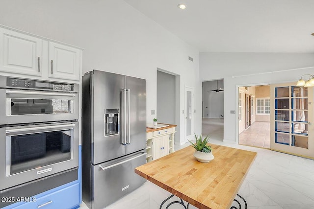 16219 S 14th Way, Phoenix, AZ 85048 - kitchen with stainless steel appliances, light marble finish flooring, white cabinetry, wooden counters, and high vaulted ceiling