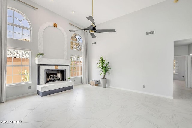 16219 S 14th Way, Phoenix, AZ 85048 - unfurnished living room with a ceiling fan, plenty of natural light, a high end fireplace, a towering ceiling, and marble finish flooring